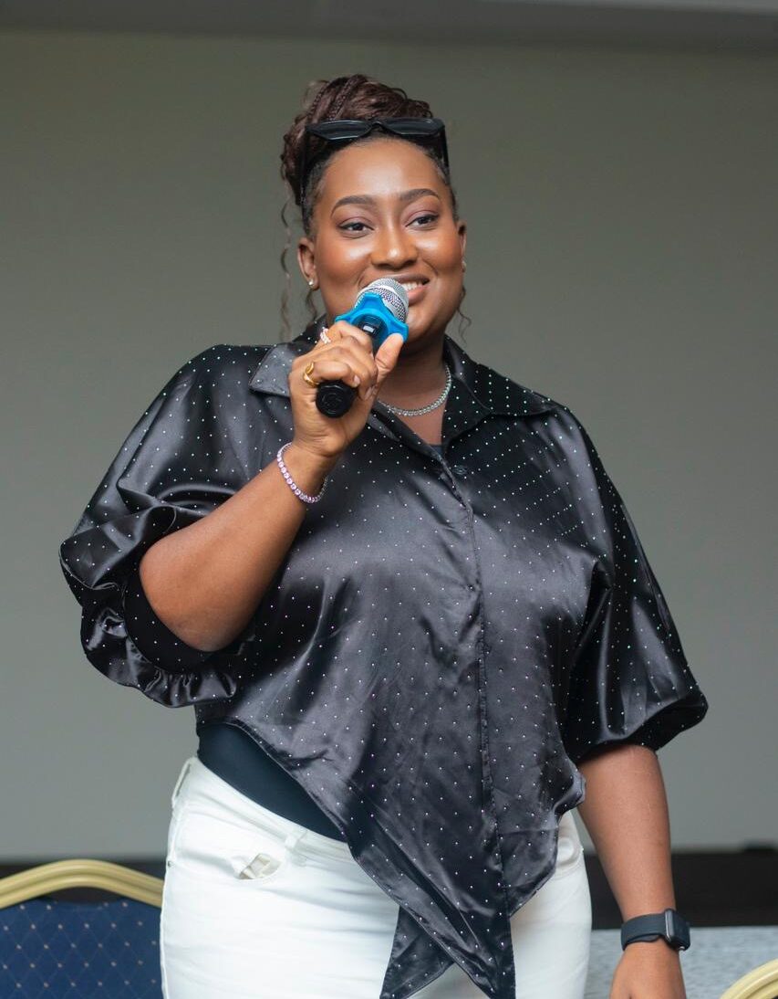 Joanna Bepeh speaking with a microphone at an event in Accra, Ghana